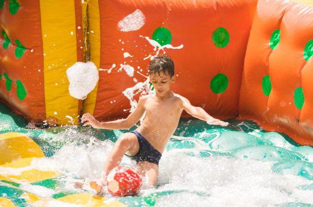 Kid Playing in orange water slide at event